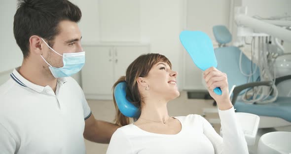 Dentist Patient Looking in Mirror and Smiling