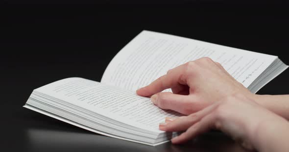 Finger pointing words on a book alt