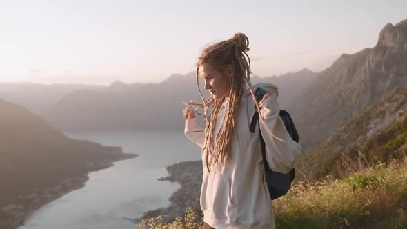 Young  hipster millennial dreadlocks woman walking trough the mountain alt