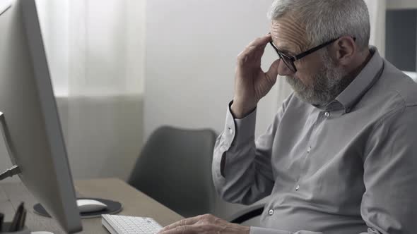 Senior man working with computer and feeling tired