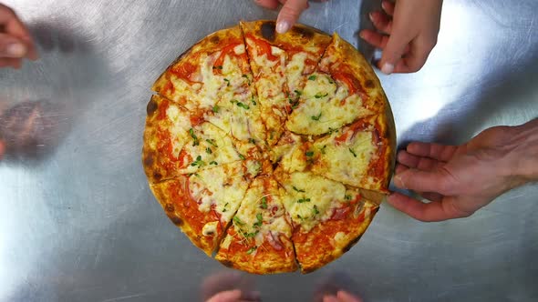 Freshly prepared pizza on a stainless steel table in a cafe kitchen. alt