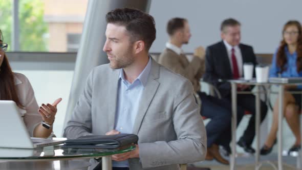 Businesspeople using laptop computer in office lobby