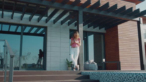 Business Woman Using Mobile at House Porch. Person Using Smartphone Near Home alt