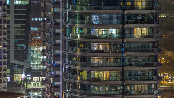 Windows of the Multistorey Building of Glass and Steel Lighting Inside and Moving People Within alt