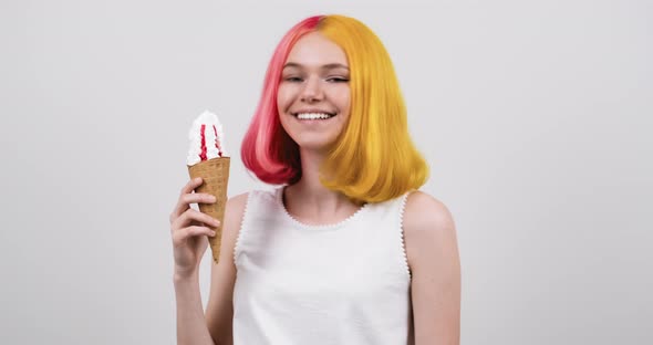Smiling Model Teenager with Ice Cream in Waffle Cone Over Light Gray Studio Background alt