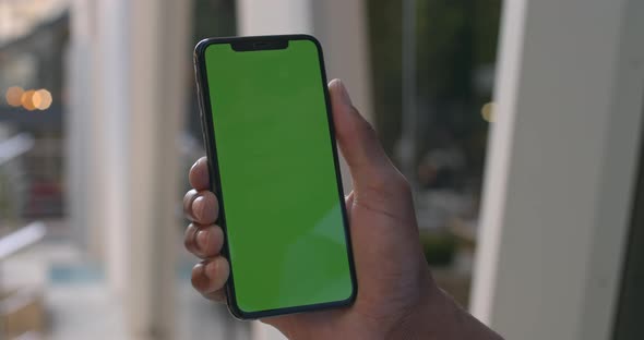 Close Up View of Male Hand Touching Modern Mobile Phone with Mock Up Screen. Afro American Man Using alt