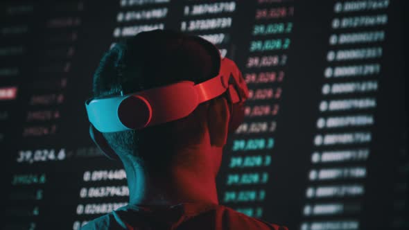 Trader in a Virtual Reality Helmet Looks at Cryptocurrency Charts alt