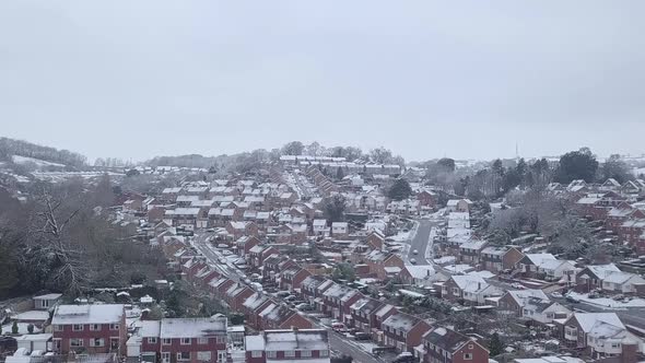 Ascending dolly forward drone shot of snowy Exeter subburbs CROP alt