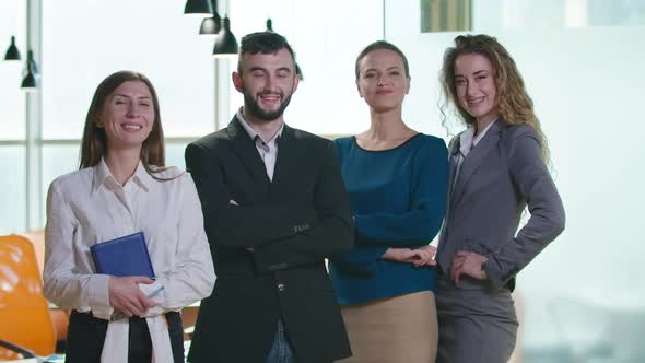 Group of Positive Confident Caucasian Women and Man Standing in Office Looking at Camera Smiling alt