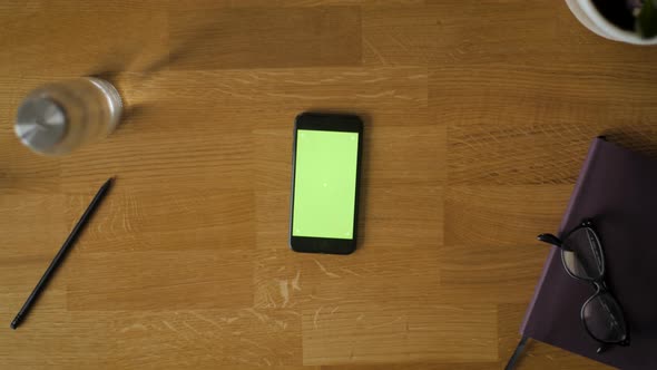 Smartphone With Green Screen On Wooden Table