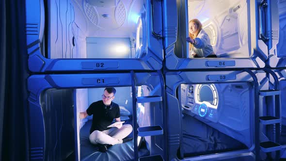 Young Man and Woman Inside of Pod Hotel Capsules alt