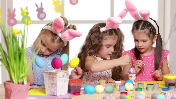 Happy Children Wearing Bunny Ears Painting Eggs on Easter Day