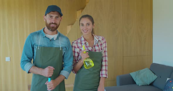 Happy Young Cleaning Company Workers Holding Cleaning Equipment alt