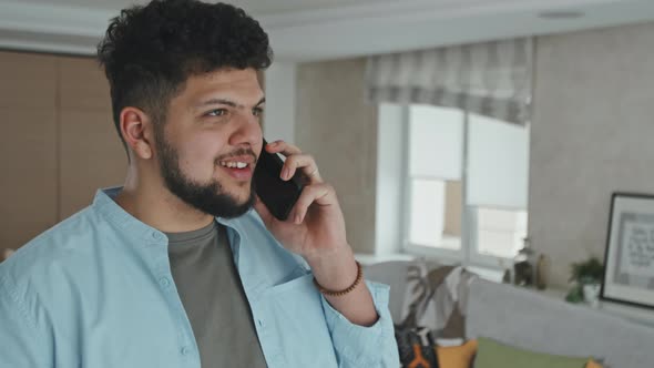Young Man Chatting On Phone In Modern Living Room alt
