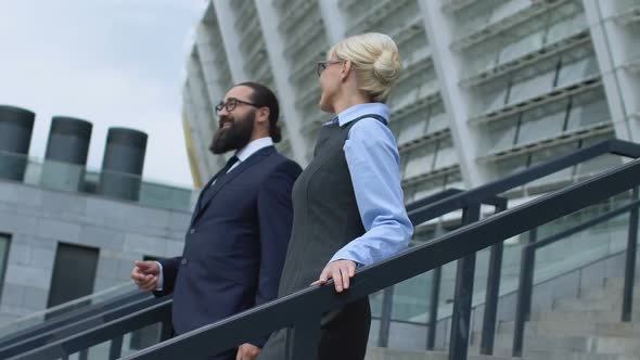 Cheerful Male and Female Colleagues Leaving Office Center and Having Talk Affair