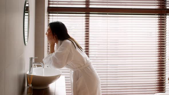 Young Beautiful Asian Lady Wearing Silk Robe Washing Face In Bathroom