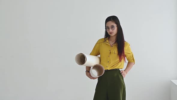 Portrait of beautiful Asian woman designer with drawings in hands. alt