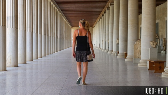 Following a Tourist Walk Down a Long Hallway of Greek Columns at Stoa of Attalos, Athens Greece alt