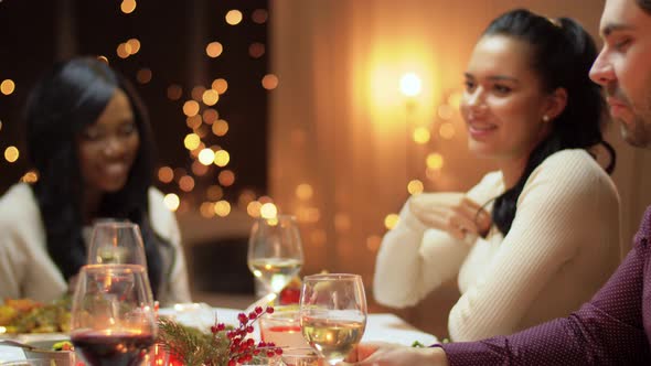 Happy Friends Having Christmas Dinner at Home alt