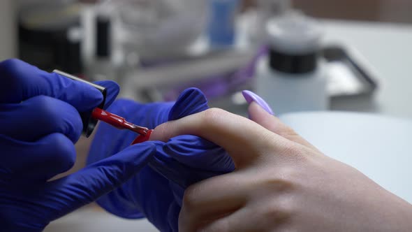 manicure master applying a nail polish