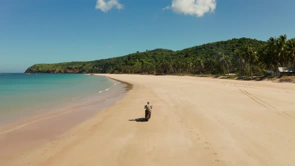 Man Driving a Motorcycle on Beach alt