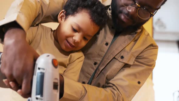 Father and son keeping screwdriver in hands together