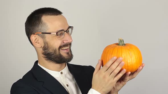 A Young Successful Businessman Holds a Ripe Organic Pumpkin in His Hands. Young Handsome Businessman