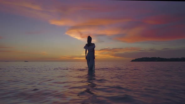 Woman Silhouette Walking Alone in the Sea at Beautiful Sunset Thailand alt
