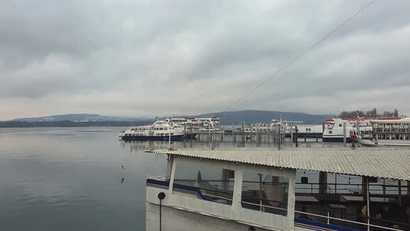 Ferry at commercial dock harbor of Arona on Lake Maggiore, Italy. Pedestal up alt
