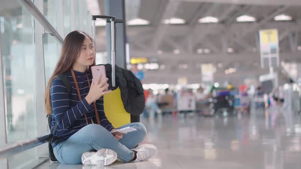 Young female traveler use smartphone calling during waiting someone 