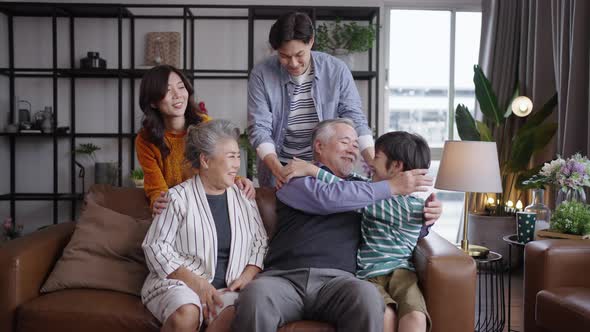 Portrait Asian family cuddling in sofa living room at home.