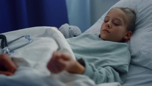 Upset Girl Lying Hospital Bed Undergoing Medical Examination in Ward Portrait alt