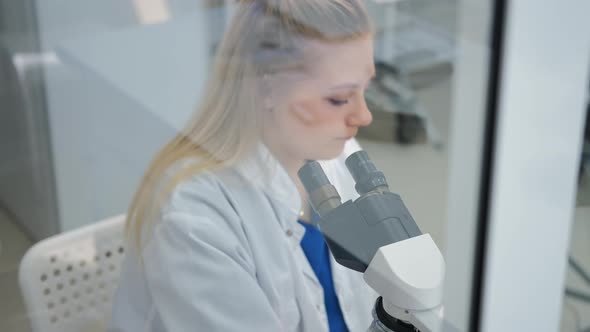 Female Scientist Looking Through a Microscope alt