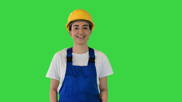 Young Woman in Yellow Hardhat Walking on a Green Screen Chroma Key alt