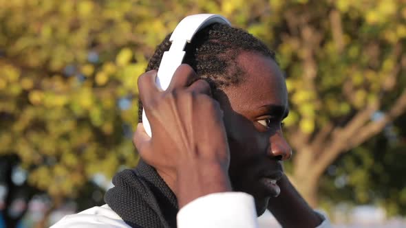 African Man Puts on Headphones and Listens To Music alt