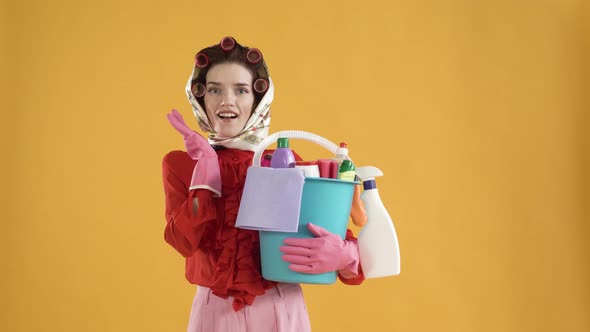 A Young Woman Holds a Bucket of Cleaning Products with a Surprised Happy Face