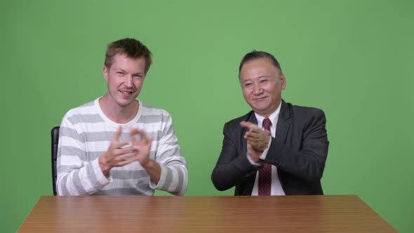 Mature Japanese Businessman and Young Scandinavian Businessman Working Together alt