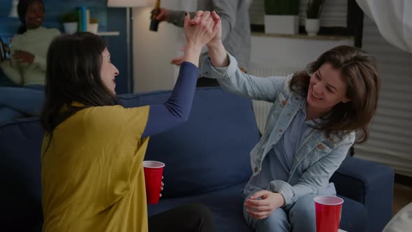 Cheerful Women Celebrating Friendship with High Five Late at Night alt