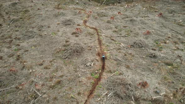 Birds Eye View Of Man Riding Mountain Bike Downhill Catching Air On Jumps alt