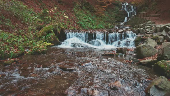 Waterfall Falling Down Mountain Slope in Autumn Forest