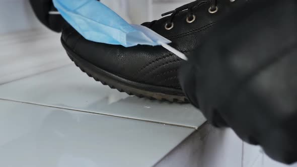 a Man Cleaned His Shoes with a Protective Medical Mask