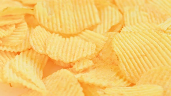 Looped Spinning Yellow Wavy Potato Chips Full Frame Closeup Background alt