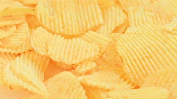 Looped Spinning Yellow Wavy Potato Chips Full Frame Closeup Background