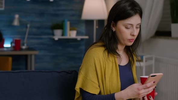 Cheerful Woman Holding Phone in Hand Browsing on Internet alt