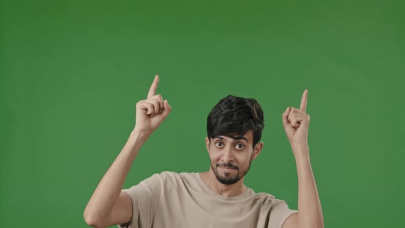 Positive Arab Man Points Forefingers Up at Copy Space for Advertisement Blank Place Recommends alt