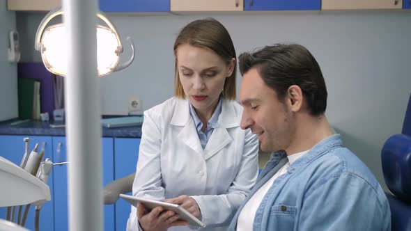 Female Dentist Showing Radiograph to Patient alt