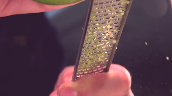 Cook grating fresh lime in kitchen alt