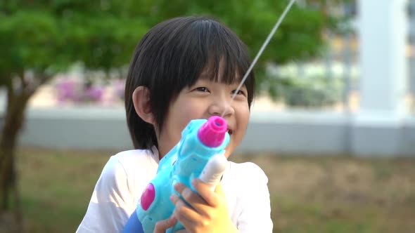 Cute Asian Child Playing With Water Gun In The Summer alt