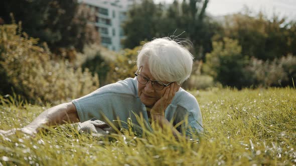 Mature Woman Lying on the Lawn. Reconecting with the Nature Concept alt