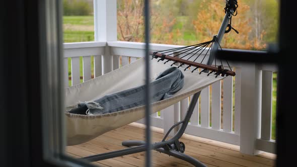 man resting in a hammock on the terrace of the house